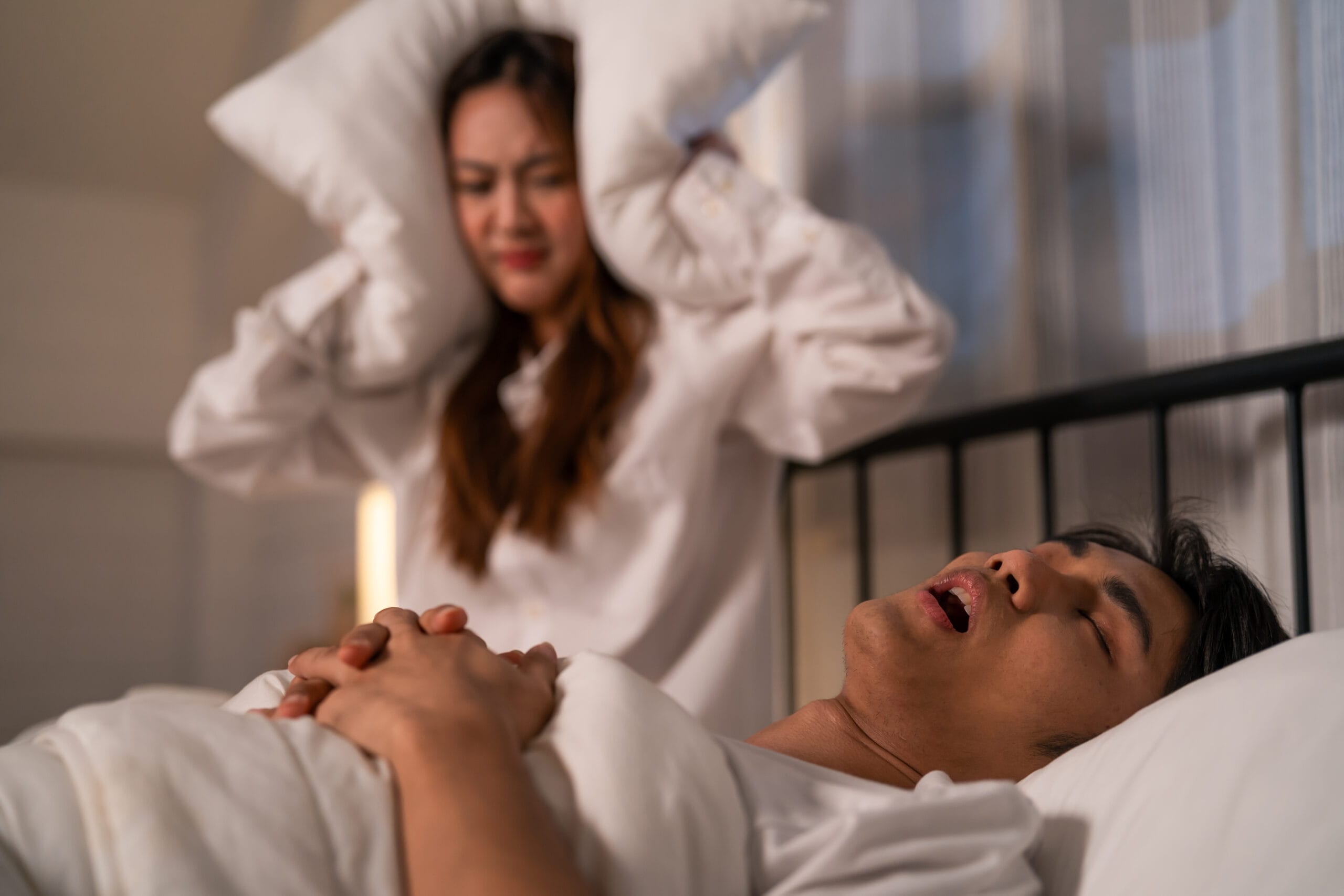 Asian woman feel frustrated from husband snoring while sleep at night Remesleep Remesleep